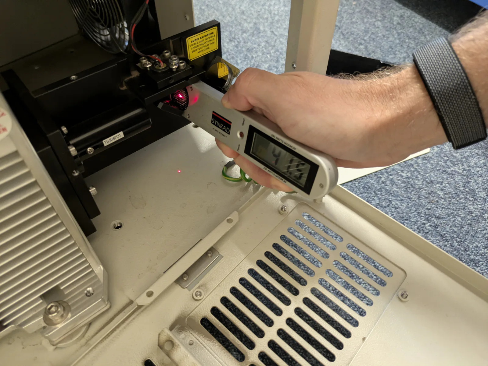 Power meter held at the direct output of a GCC laser tube during measurement